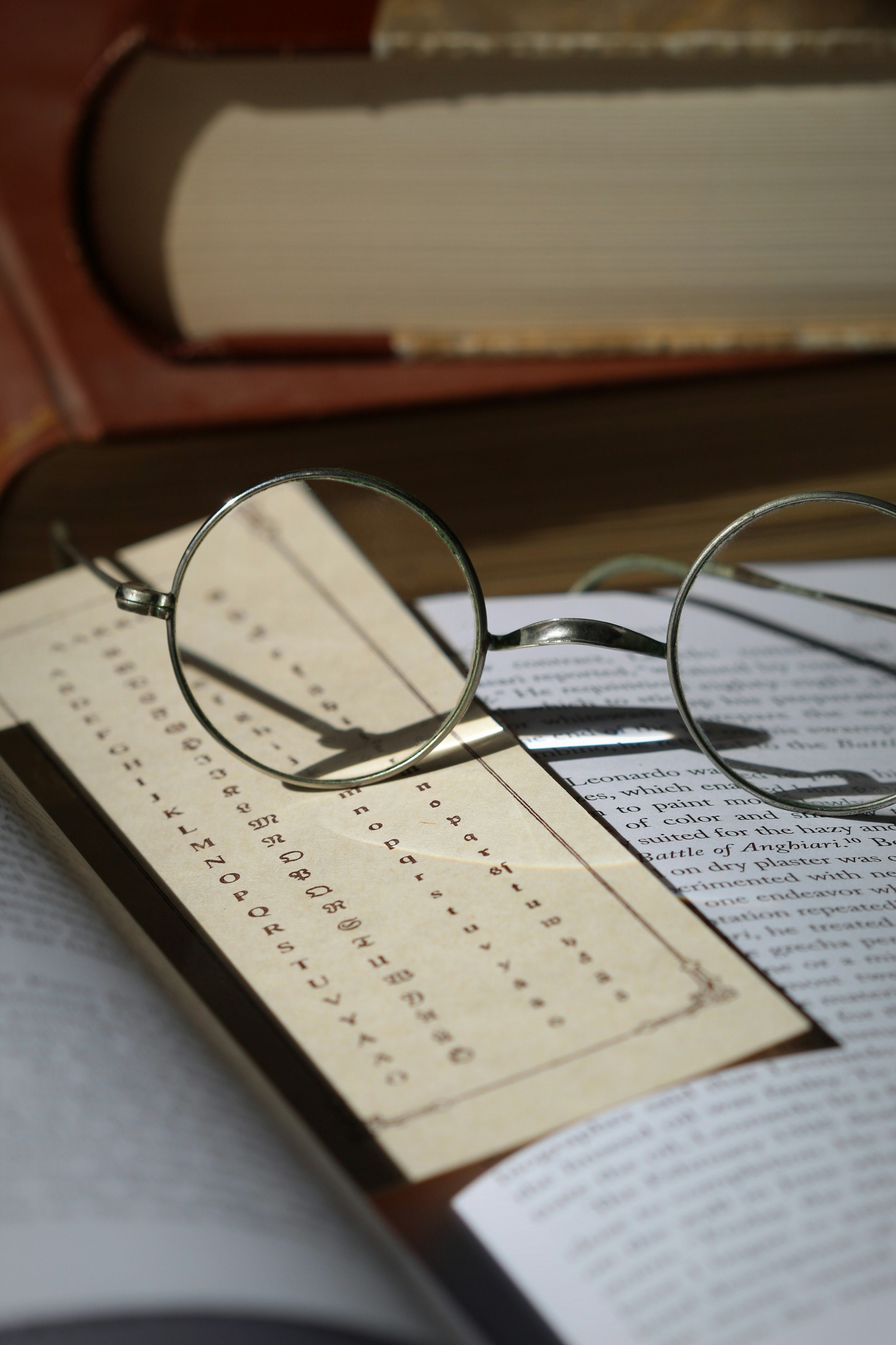 Research materials, books, and eyeglasses representing ideas and intellectual work
